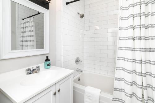 a white bathroom with a sink and a tub at Salisbury Hideaway in Salisbury