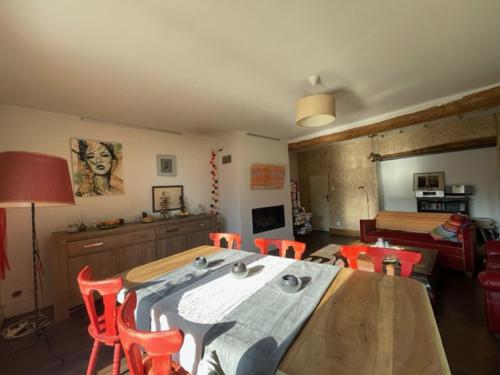 una sala da pranzo con tavolo e sedie e un soggiorno di La Maison Bliss a Piolenc