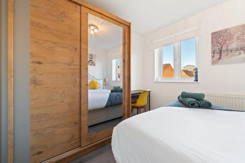 a bedroom with a large wooden closet and a bed at 7Nights Special l Modern House near City Center Sleeps 6 with Free Parking l By Zen Nights Short Lets & Serviced Accommodations in Leicester