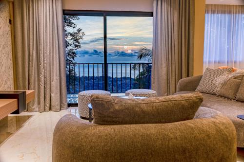 a living room with a couch and a large window at The Country Lodge Hotel in Freetown