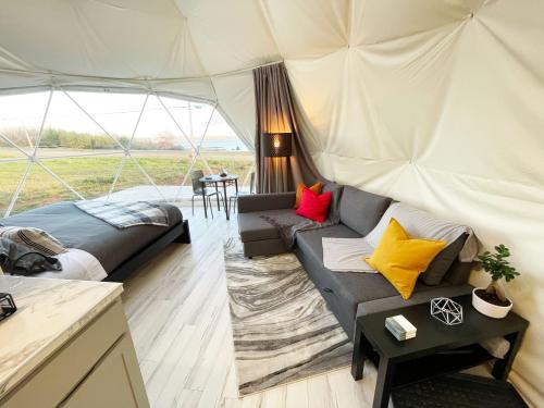 a living room with a couch in a tent at Port Wade Glamping Domes in Victoria Beach 