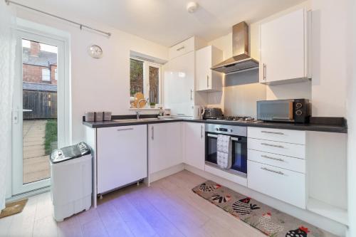 a white kitchen with a sink and a stove at Last-Minute Reserve l Modern House near City Center Sleeps 6 with Free Parking l By Zen Nights Short Lets & Serviced Accommodations in Leicester