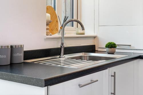 a stainless steel sink in a white kitchen at Luxury house close to city center sleeps 6 with free parking in Leicester