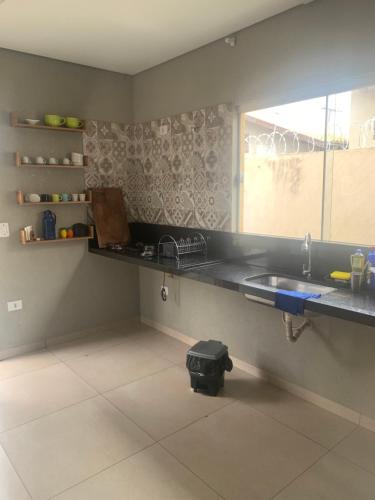 cocina con fregadero y ventana en Linda Casa Próximo Aeroporto en Campo Grande