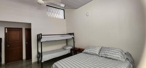 a bedroom with a bed and bunk beds in it at Casa villa con Jacuzzi, tobogán y BBQ in Carmen de Apicalá