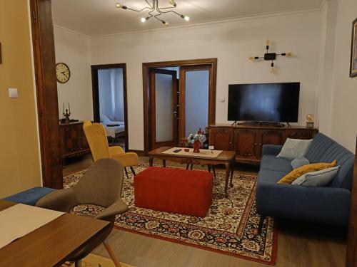 a living room with a blue couch and a tv at City centre stylish apartament with private backyard in Sofia
