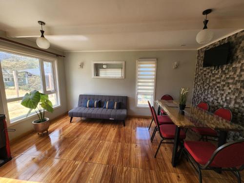 ein Wohnzimmer mit einem blauen Sofa und einem Tisch in der Unterkunft Casa familiar in Cochrane