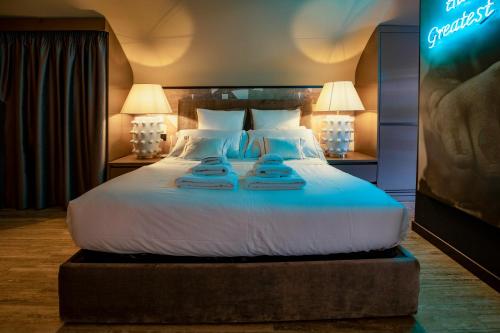 a large bed in a hotel room with two lamps at CadensPlace - Overlooking Piazza Navona by dbalconycollection in Rome