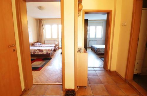 a room with two beds and a hallway with a bedroom at Fantazy Apartment Main Square in Skopje
