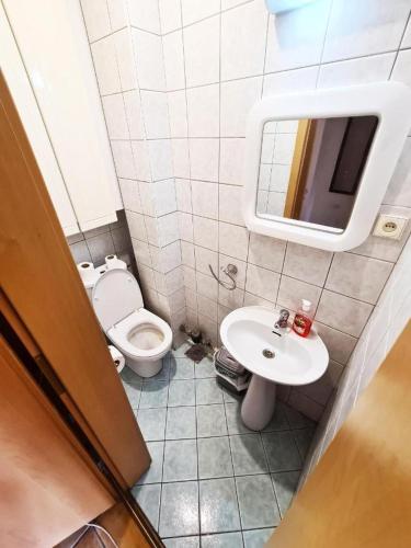 a bathroom with a toilet and a sink and a mirror at Fantazy Apartment Main Square in Skopje