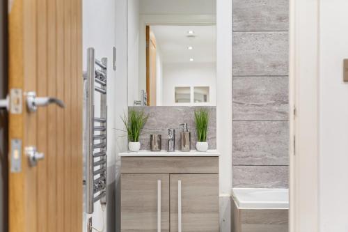 a bathroom with a sink and a mirror at Modern Apartment with Pool table in Leicester