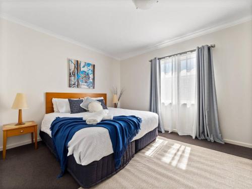 una camera da letto con un letto grande e una finestra di Self contained Resort Apartment 2PAX a Mandurah