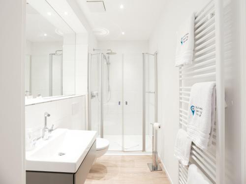 biała łazienka z umywalką i toaletą w obiekcie business boarding lippstadt w mieście Lippstadt