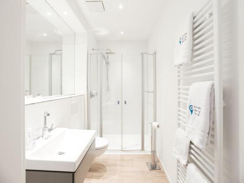 a white bathroom with a sink and a toilet at business boarding lippstadt in Lippstadt