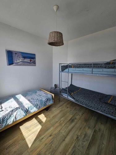 deux lits superposés dans une chambre avec parquet dans l'établissement Gite canard, à Fromelles