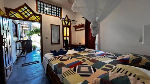阿魯岡灣的住宿－Hakuna Matata Arugambay，一间卧室配有一张带五颜六色被子的床