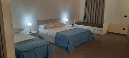 a hotel room with two beds and a window at Villaggio Jonio Blu in Bianco
