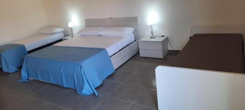 a hotel room with two beds and two tables at Villaggio Jonio Blu in Bianco