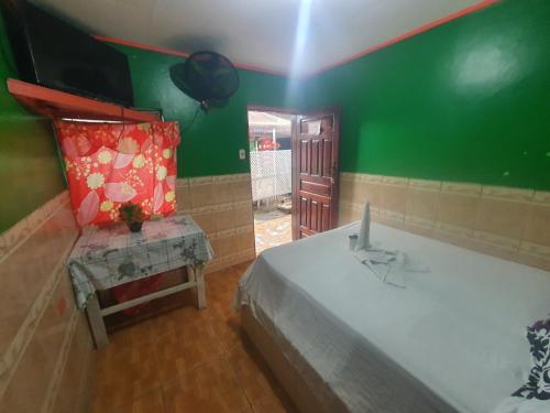 1 dormitorio con cama y pared verde en Hotel Economica, en Roatán