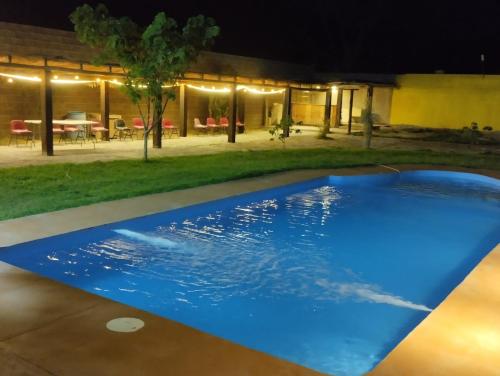 a blue swimming pool in a yard at night at Descanso los palmitos in Cuatrociénegas de Carranza