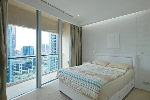 a bedroom with a bed and a large window at Emaar Residences Fashion Avenue - Formerly Address Dubai Mall in Dubai