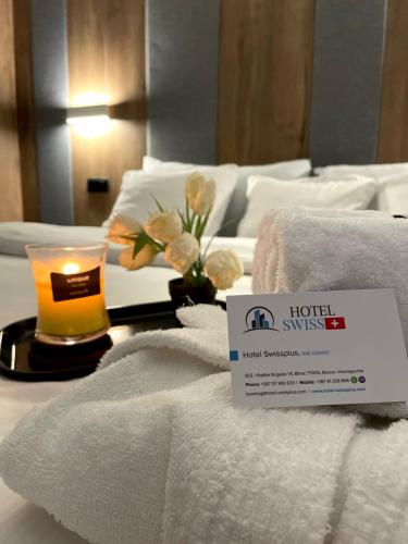 a hotel room with towels and a candle on a bed at Swiss Plus Hotel in Bihać