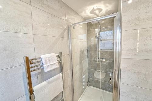 um chuveiro com uma porta de vidro na casa de banho em Central and Stylish, Garden and Parking em Coventry