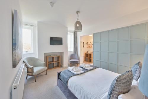 a bedroom with a bed and a chair and a television at Rooms at The Dressers Arms in Chorley