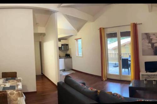 un salon avec un canapé et une cuisine dans l'établissement Appartement au bord du lac, à Lacanau