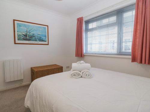 a bedroom with a white bed with two towels on it at Riverview Apartment in Cemaes Bay