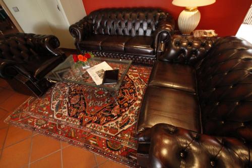 a living room with a leather couch and a table at Fetzers Landhotel in Ingelheim am Rhein