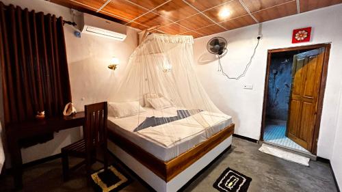 a bedroom with a bed with a mosquito net at Hakuna Matata Arugambay in Arugam Bay