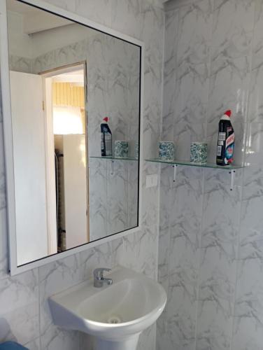 a white bathroom with a sink and a mirror at Cabaña Curanipe Playa in Curanipe