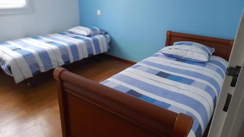 - 2 lits dans une chambre à rayures bleues et blanches dans l'établissement Maison de 3 chambres avec jardin clos et wifi a Champcueil, à Champcueil
