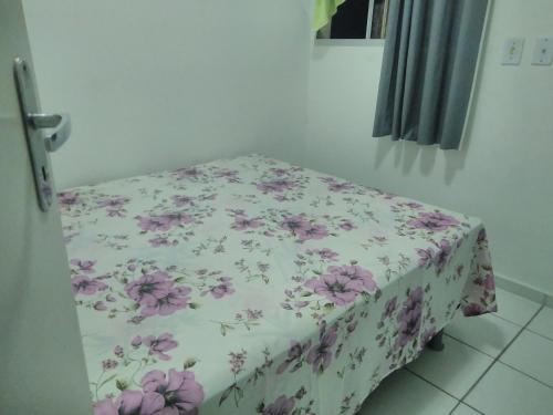 un letto in una camera con coperta a fiori di APTO 201 completo temporada Maceió (DIARIA) a Maceió