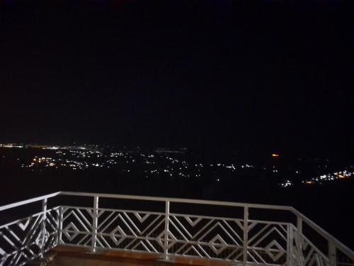 een brug over het water met een stad in de nacht bij Cozy room in a house in Kigali