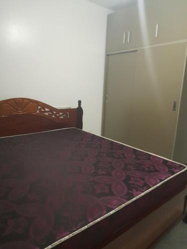 een slaapkamer met een bed en een kast met een deur bij Cozy room in a house in Kigali