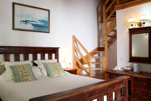 a bedroom with a bed with a mirror and a staircase at Ronda Nomads in Benaoján