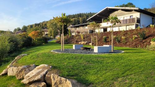 una casa en la cima de una colina con un patio en BayVista, die Bayerwald Lodge en Lam