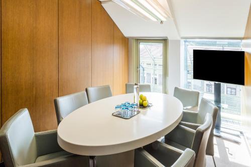 a dining room with a white table and chairs at Holiday Inn Express Paris-Canal De La Villette by IHG in Paris