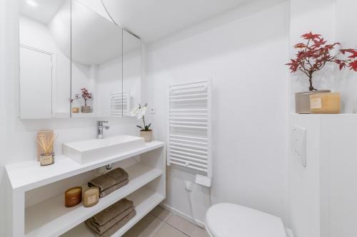 uma casa de banho branca com um lavatório e um espelho em Imhost 8 - Lovely studio at St Michel-Notre Dame em Paris