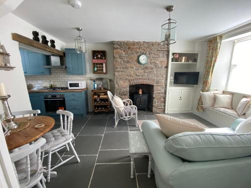 a living room with a couch and a fireplace at Cosy Fisherman’s Cottage: 150m to Brixham Harbour in Brixham