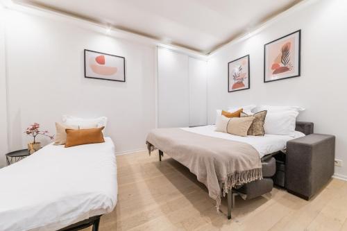 Duas camas num quarto com paredes brancas em Imhost 8 - Lovely studio at St Michel-Notre Dame em Paris