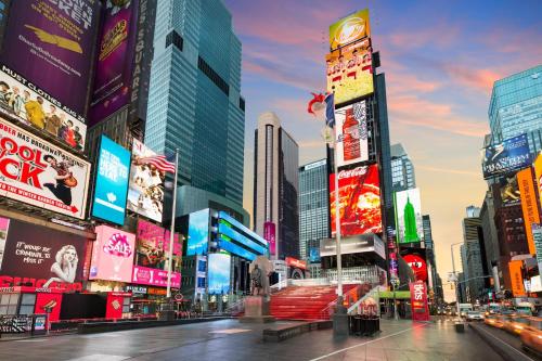 una calle de la ciudad con muchos edificios altos y carteles en Crowne Plaza Times Square Manhattan, an IHG Hotel, en Nueva York