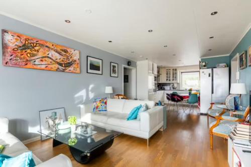 un soggiorno con divano bianco e tavolo di Cosy room in a family flat a Oslo