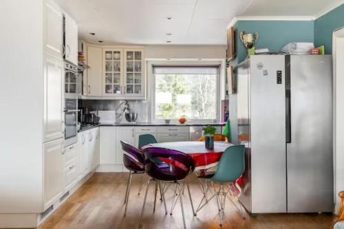a kitchen with a table and chairs and a refrigerator at Cosy room in a family flat in Oslo