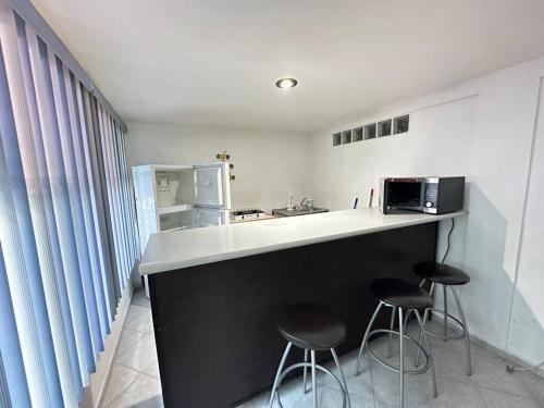 uma cozinha com 2 bancos e um balcão com um frigorífico em Suite#10 Cerca de Auto. Mex-Qro. em Cuautitlán Izcalli