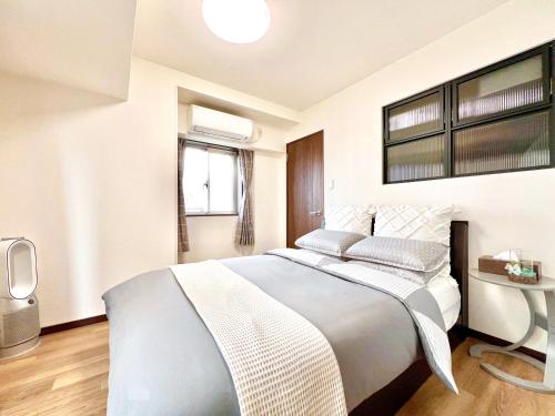 a white bedroom with a large bed and a window at East Ikebukuro 2 Double Beds Apartment / Sunshine City in Tokyo
