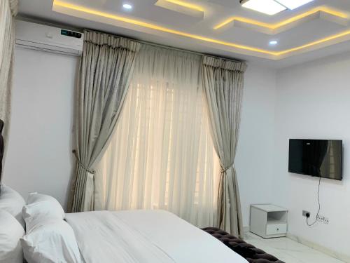 a bedroom with a bed and a tv on a ceiling at The Residenze Adeniyi Jone Ikeja in Lagos