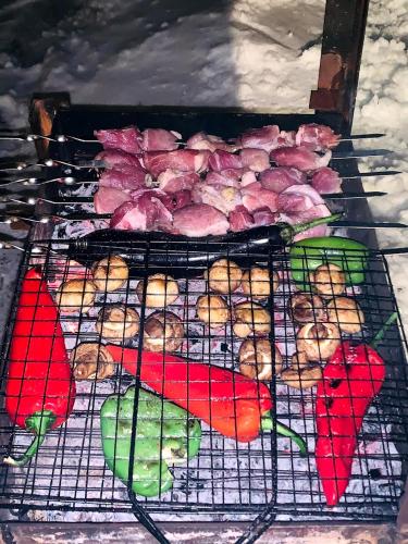 a grill with meat and fruit on top of it at AVIATOR Apartments in Bakuriani in Bakuriani